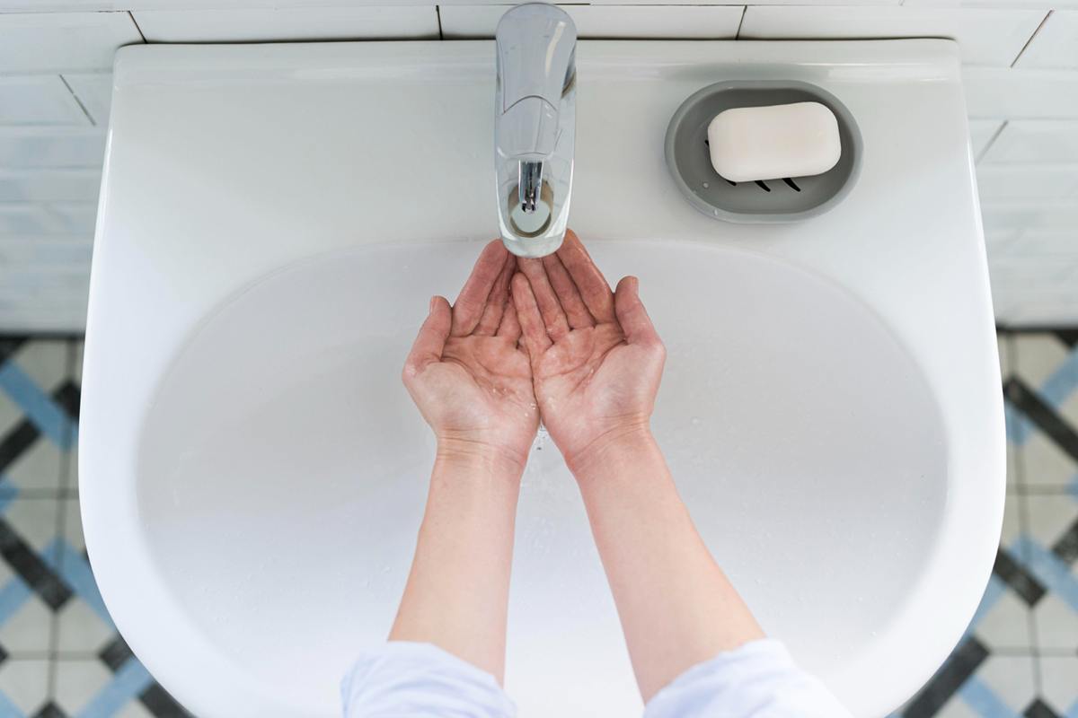 Clean hand sink with soap, paper towels, and handwashing sign