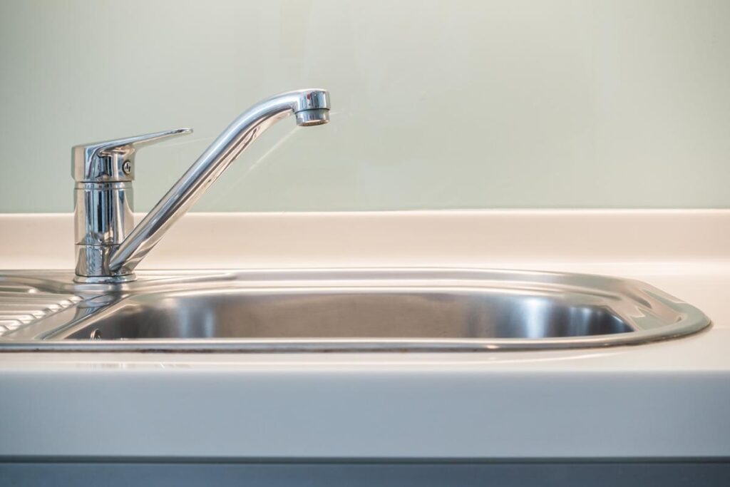 Touchless faucet on stainless hand wash sink in restaurant

